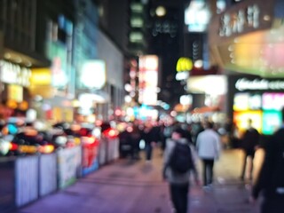 Abstract bokeh image of crowded Hong Kong street at night with bright neon lights.