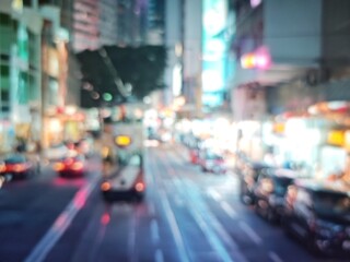 Abstract bokeh image of Hong Kong city street at night, with blurred lights and vehicles.