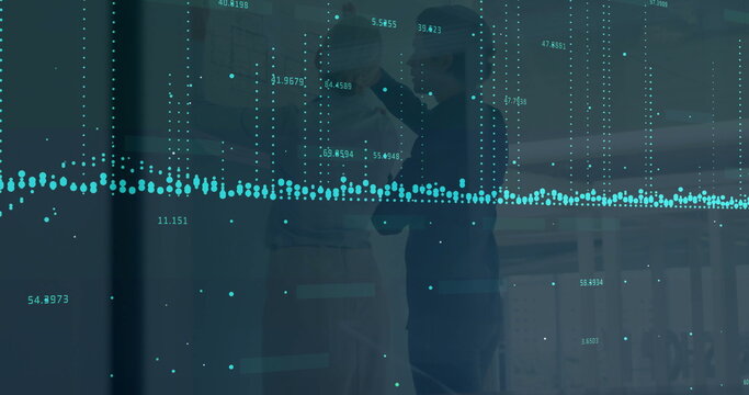 Pointing colleagues leaning forward interpreting data at office glass panel, with teal data overlay
