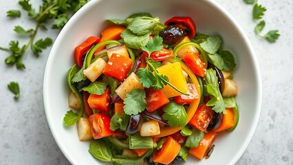 A fresh vegetable salad in a white bowl, garnished with herbs and captured from a top-down view.