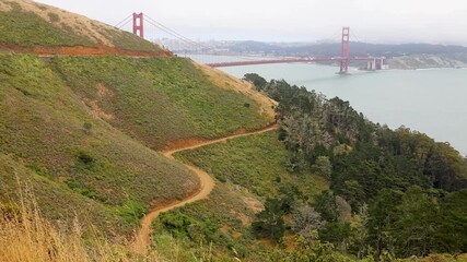 Winding path on Marin Headlands hillside, view of Golden Gate Bridge and San Francisco Bay, lush greenery and forest
 - Powered by Adobe