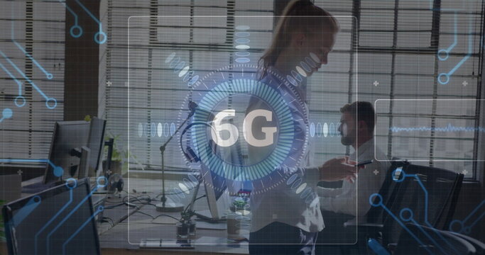 Gesturing businesswoman presenting 6G interface in modern office, with multiple monitors - Powered by Adobe