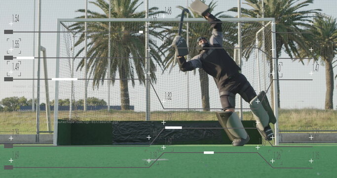 Diving to right blocking shot on field hockey turf, with net and protective gear, copy space