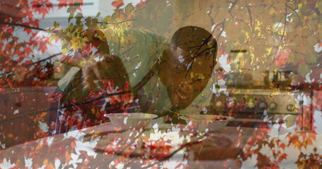 Leaning home cook tasting with spoon in home kitchen, with white bowl, cookbook and autumn leaves