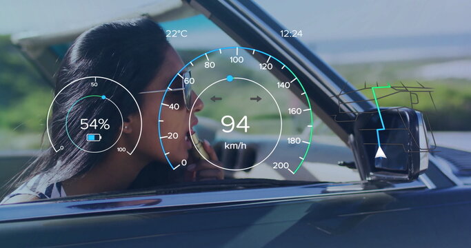 Applying lipstick Indian woman in aviator sunglasses driving convertible by coast, with HUD overlay - Powered by Adobe