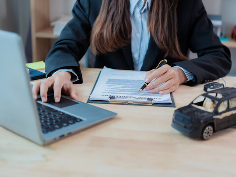 Car dealer or sales manager offers to sell a car and explains the conditions for signing a car contract and insurance contract. Close-up photo