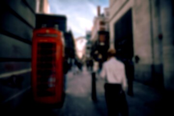 A red telephone booth on a UK street, blurred background with bokeh.