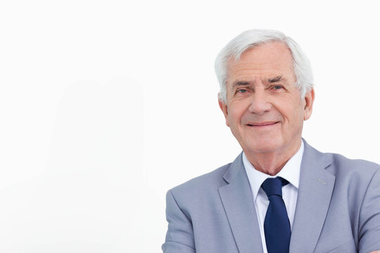 Senior male professional posing wearing grey suit and blue tie at studio portrait, copy space