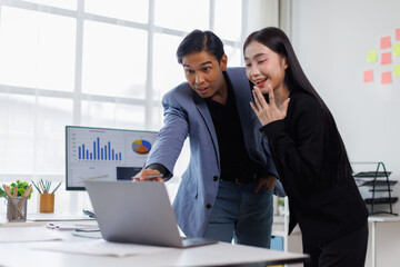 Two Young Asian business couple working together, completing the assigned work
