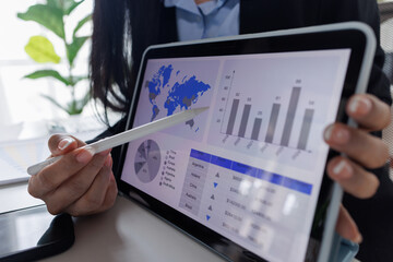 Business asian woman working at office with tablet and document, doing planning analyzing the financial report, business plan investment, finance analysis concept. Economic business discussions.
