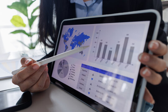 Business asian woman working at office with tablet and document, doing planning analyzing the financial report, business plan investment, finance analysis concept. Economic business discussions.
