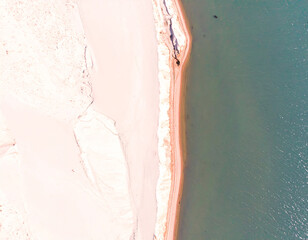 Fototapeta premium Summer seascape beautiful waves, blue sea water in sunny day. Top view from drone. Sea aerial view, amazing tropical nature background. Beautiful bright sea with waves splashing and beach sand concept