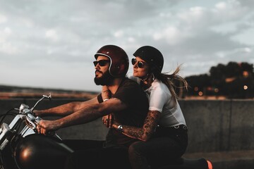 Biker couple riding during sunset