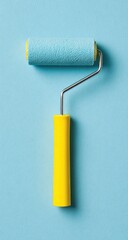 Obraz premium A light-blue paint roller with a bright-yellow handle, positioned vertically against a pale-blue backdrop