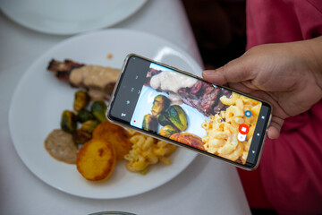 Person Photographing a Plated Meal &ndash; Mac and Cheese, Roasted Vegetables, and Meat in Sauce
