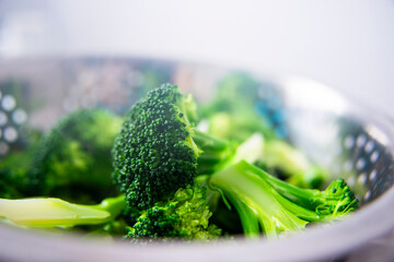 Hot Steamed Broccoli in Metal Colander &ndash; Kitchen Utensil and Cooking Steam Close‑Up
