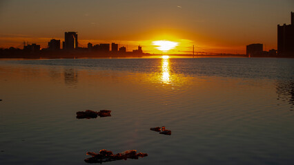 Looking at the sunset under the Ambassador Bridge in Detroit Michigan from Belle Isle, in February cold while still some ice in the Detroit river. 