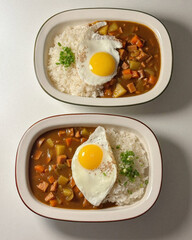 Two curry plates with rice and eggs.