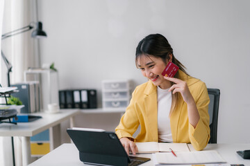 Happy businesswoman making online payment using tablet and credit card