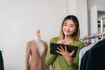Fashion designer working on digital tablet in her atelier