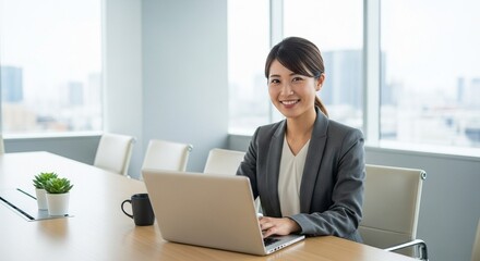 パソコンの前で笑顔を浮かべる若手女性社員のポートレート