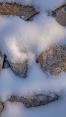 Close up of textured stones covered in a light dusting of snow