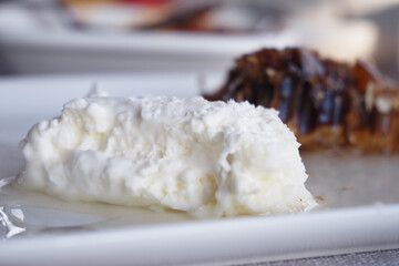 Close-Up of Creamy Dessert with Coconut Flakes and Chocolate Topping