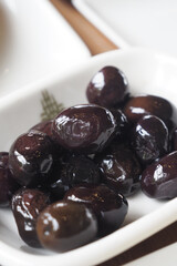 Fresh black olives served in a white dish