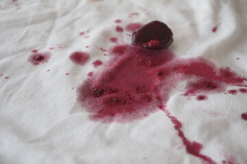 red wine stains spread across a white piece of fabric