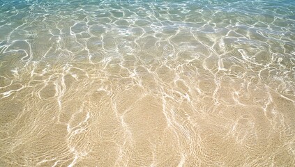 A close-up aerial view of the pristine white sandy beach and turquoise ocean waves in Bora Bora, capturing the serene beauty with a soft focus on gentle ripples. The composition is centered around