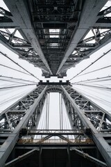Fototapeta premium a bridge's architectural elegance, with its unique geometric design, capturing a stunning skyward perspective. The bridge's metal structure is a testament to engineering and design