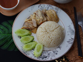 Khao Man Gai — Thai-style Hainanese chicken rice featuring tender boiled chicken served with aromatic chicken oil rice, rich soy-based dipping sauce, and fresh cucumber slices. A beloved Thai comfort 