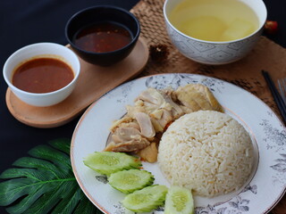 Khao Man Gai &mdash; Thai-style Hainanese chicken rice featuring tender boiled chicken served with aromatic chicken oil rice, rich soy-based dipping sauce, and fresh cucumber slices. A beloved Thai comfort 