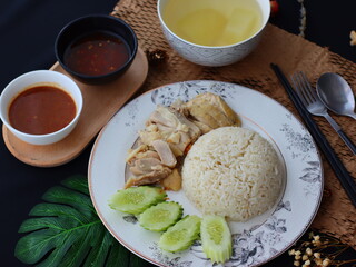 Khao Man Gai &mdash; Thai-style Hainanese chicken rice featuring tender boiled chicken served with aromatic chicken oil rice, rich soy-based dipping sauce, and fresh cucumber slices. A beloved Thai comfort 
