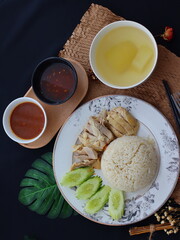 Khao Man Gai — Thai-style Hainanese chicken rice featuring tender boiled chicken served with aromatic chicken oil rice, rich soy-based dipping sauce, and fresh cucumber slices. A beloved Thai comfort 