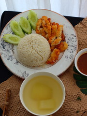 Khao Man Gai Tod — Thai-style crispy fried chicken served with fragrant chicken oil rice, accompanied by a savory dipping sauce and sliced cucumber. A popular street food dish in Thailand, combining j