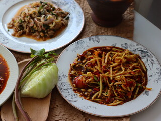 Som Tum — a vibrant and spicy Thai green papaya salad made with shredded unripe papaya, garlic, chili, lime juice, fish sauce, and palm sugar. This iconic street food dish from Thailand is known for i