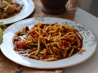 Som Tum — a vibrant and spicy Thai green papaya salad made with shredded unripe papaya, garlic, chili, lime juice, fish sauce, and palm sugar. This iconic street food dish from Thailand .