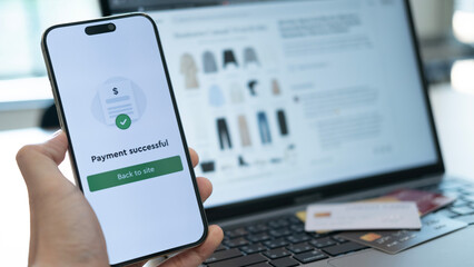Holding a phone with payment success displayed, and a credit card placed below, highlighting the convenience of cashless payment systems used anywhere