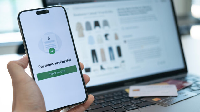 Holding a phone with payment success displayed, and a credit card placed below, highlighting the convenience of cashless payment systems used anywhere