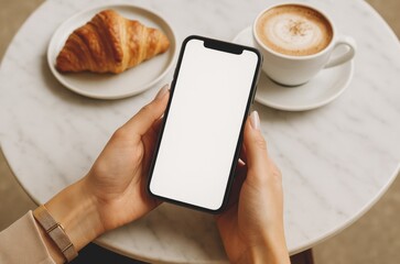 Mockup, woman's hands holding mobile phone with blank screen in coffee shop.