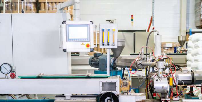 Plastic extrusion machine with control panel in smart factory. Polymer processing, automation technology and industrial production.