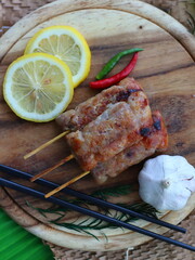 Grilled fermented pork sausage (Naem Yang) — a popular Thai snack with tangy, smoky flavors, grilled to perfection for a crispy exterior and chewy inside.