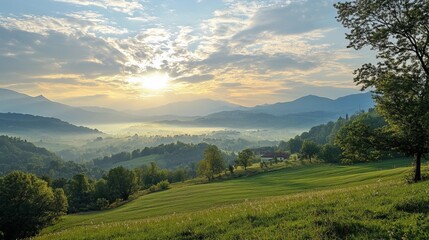 Obraz premium Panoramic vista of a valley at sunrise, misty mountains, lush greenery