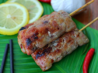 Grilled fermented pork sausage (Naem Yang) — a popular Thai snack with tangy, smoky flavors, grilled to perfection for a crispy exterior and chewy inside.