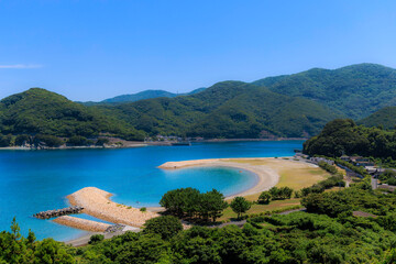 澄んだ青い海と緑の山が広がるムーンビーチ井野浦の絶景風景

