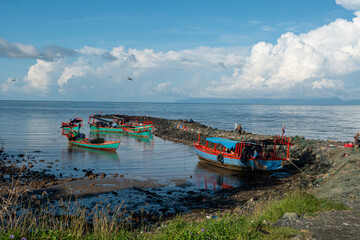 Naklejka premium Traditional crab and seafood market at sunrise in Kep, Cambodia – fishing boats arriving at pier