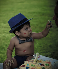 Mexican baby with messy hands from a cake