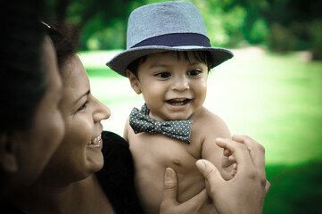A Mexican baby being held by his Aunt, while his mom is beside her