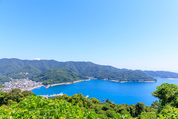 愛媛県伊方町の三崎港を見渡す夏の絶景。青い海と緑の山々、澄んだ空が広がる風景。

